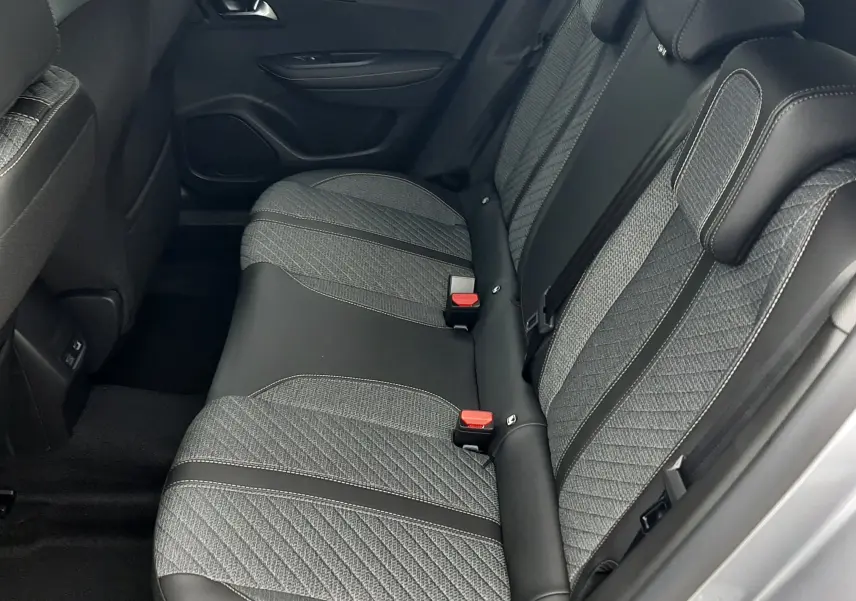 Vue latérale droite de la banquette arrière en tissu gris et cuir noir du Peugeot 2008 gris Artense 2025.