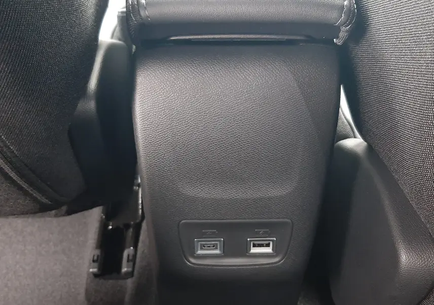 Prise USB-C et USB-A en bas du tunnel central arrière d’un Peugeot 2008 gris Artense 2025 hybride.