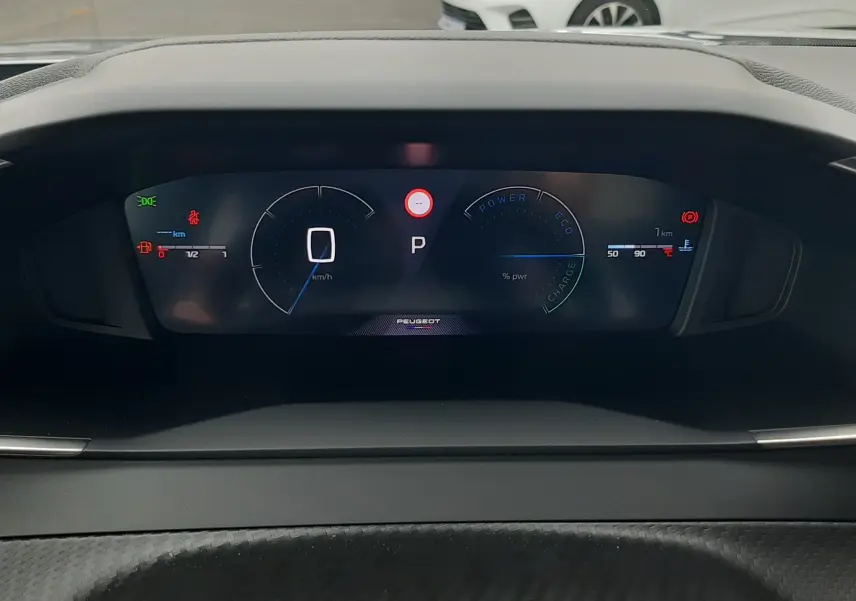 Tableau de bord numérique du Peugeot 2008 gris Artense, affichant vitesse et mode hybride en vue frontale.