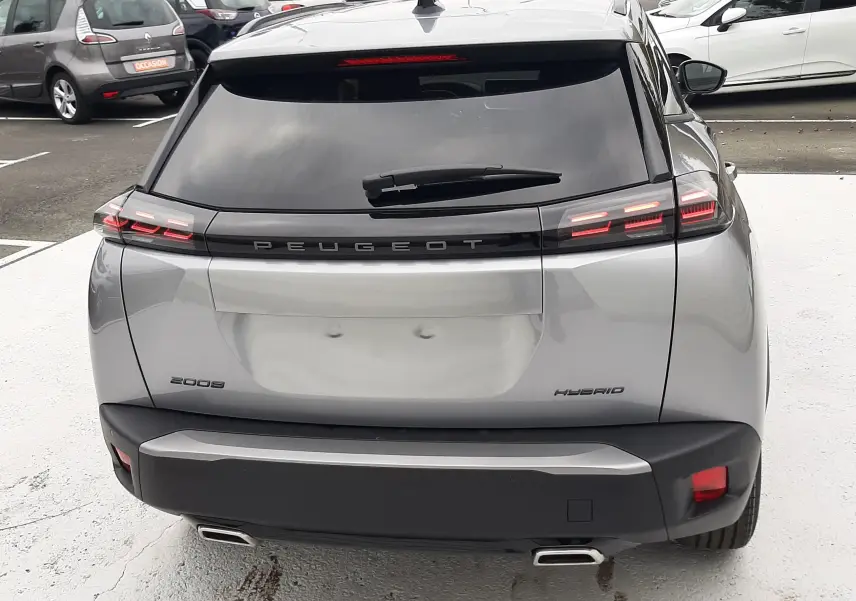 Vue arrière d'un Peugeot 2008 gris Artense hybride 2025 avec feux LED et double sortie d'échappement chromée.