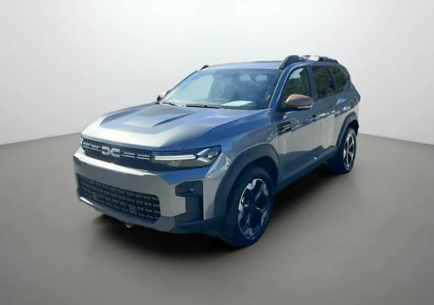 Vue 3/4 avant du Dacia Bigster gris schiste 2025 avec jantes noires et détails noirs sur les ailes.