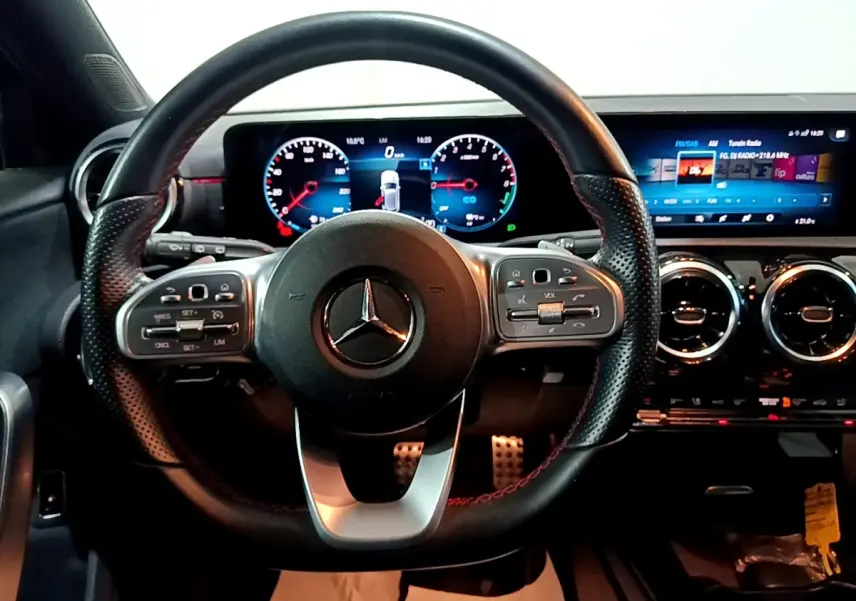 Vue rapprochée du volant cuir et alu d’une Mercedes Classe A 250 e AMG Line 2021 avec tableau de bord numérique.