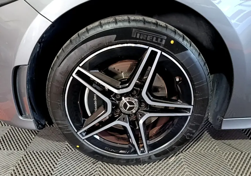 Gros plan sur la roue avant droite gris foncé d'une Mercedes Classe A 250 e AMG Line avec jante AMG noire et argent.