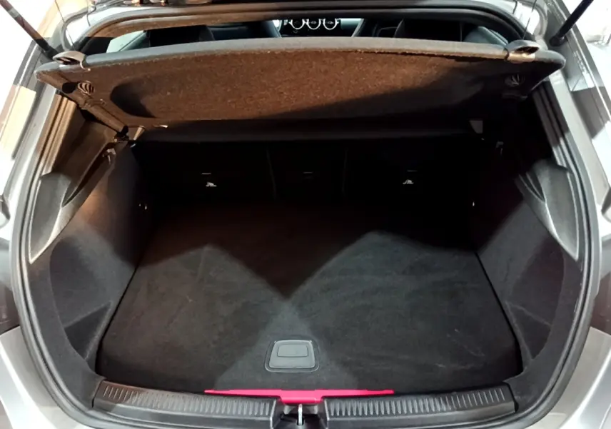 Coffre ouvert vu de dessus d'une Mercedes Classe A 250 e AMG Line gris foncé, montrant l'espace de chargement vide.
