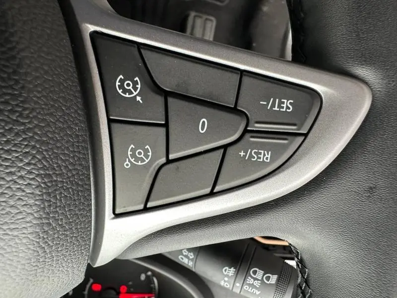 Gros plan sur les commandes de régulateur de vitesse au volant du Dacia Jogger brun Terracota 2024.