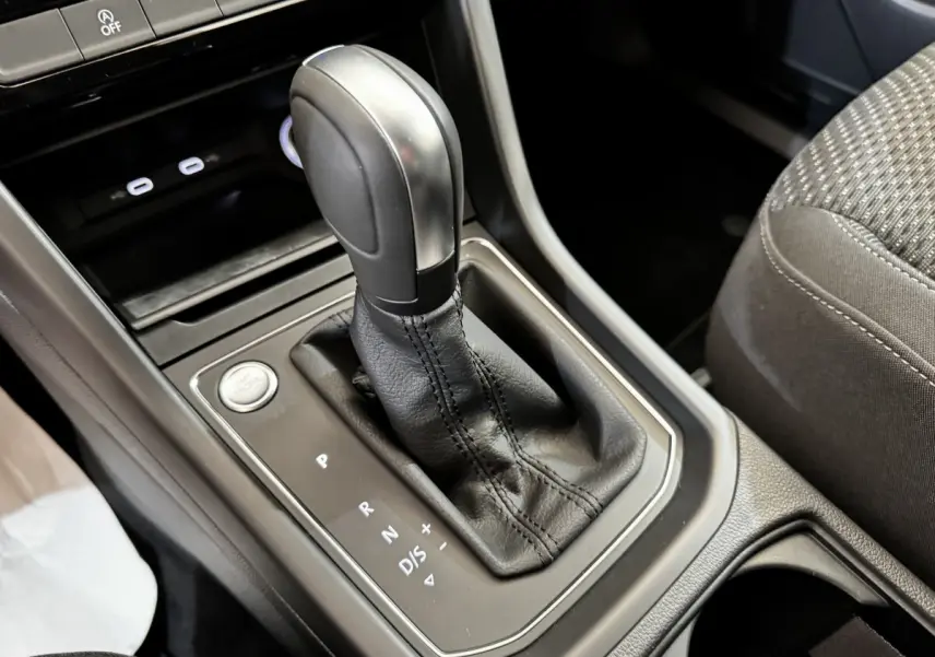Gros plan sur la commande de boîte automatique noire et levier de vitesse dans l'habitacle du Volkswagen Touran 2024.