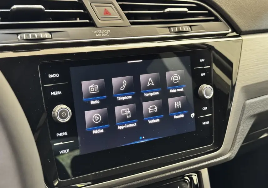 Vue rapprochée de l’écran tactile central noir du tableau de bord du Volkswagen Touran 2024, affichant le menu multimédia.