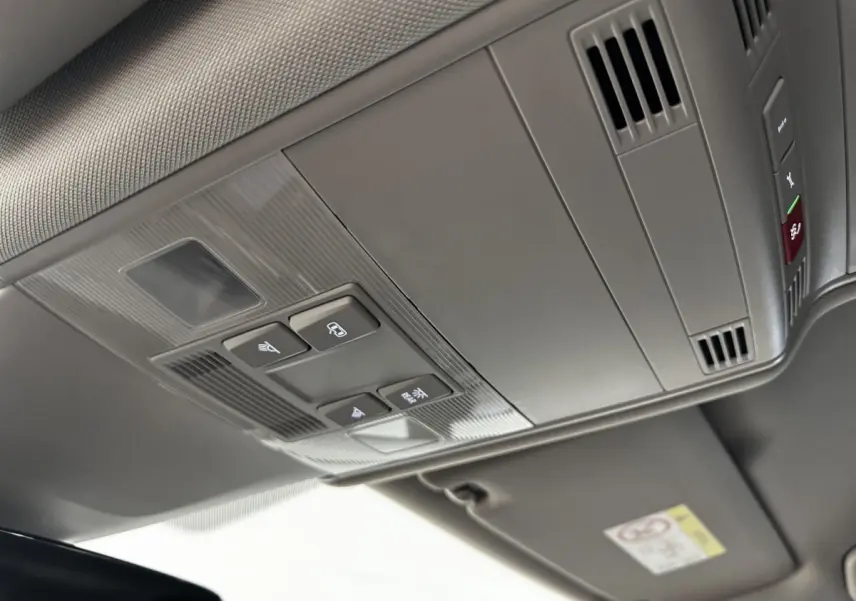 Vue en plongée sur le plafonnier gris du Volkswagen Touran 2024 avec commandes d’éclairage et ventilation intégrées.