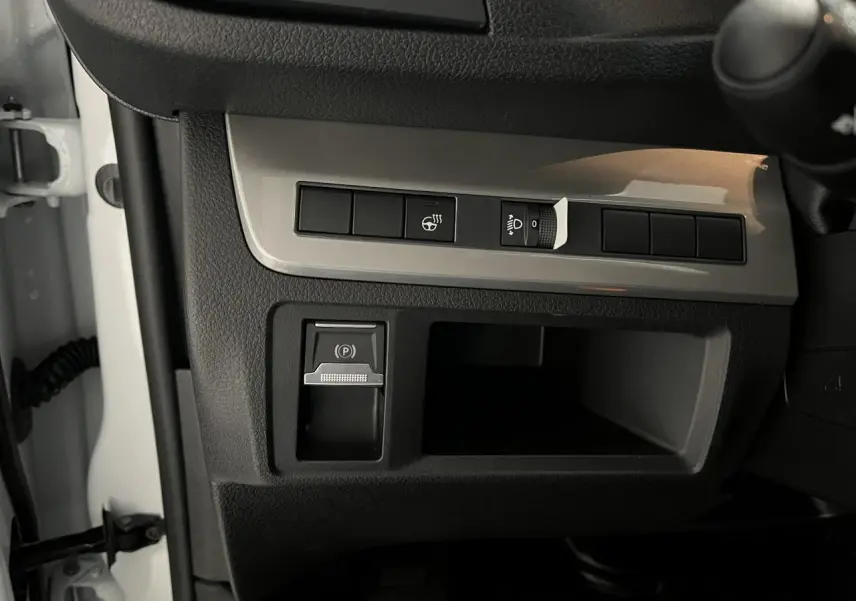 Détail du tableau de bord noir et gris du Peugeot Expert Fourgon blanc 2024 avec frein de stationnement électrique.