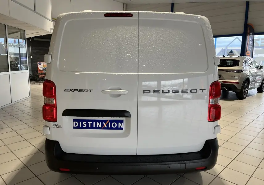Vue arrière d'un Peugeot Expert Fourgon blanc 2024 avec feux rouges verticaux et logo distinctif sur portes battantes.