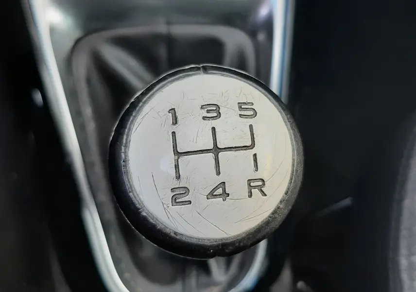 Gros plan sur le pommeau de la boîte manuelle gris et noir d'une Citroën C3 noire de 2016.