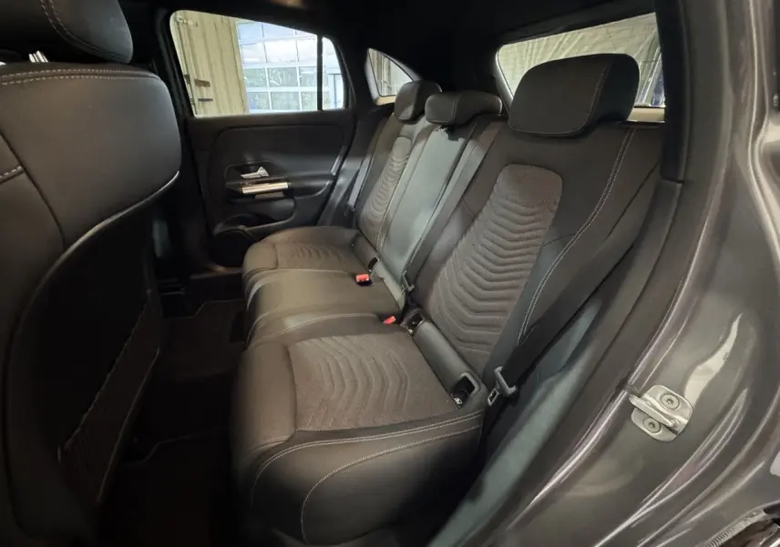 Vue intérieure côté droit montrant la banquette arrière en tissu noir du Mercedes GLA 250 e Business Line gris foncé 2023.