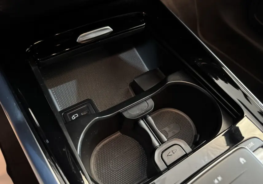 Gros plan sur les porte-gobelets noirs et la console centrale brillante du Mercedes GLA 250 e Business Line 2023.