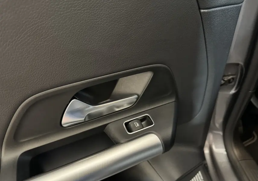 Détail de la porte arrière droite gris foncé du Mercedes GLA 250 e avec poignée argentée et bouton de verrouillage.