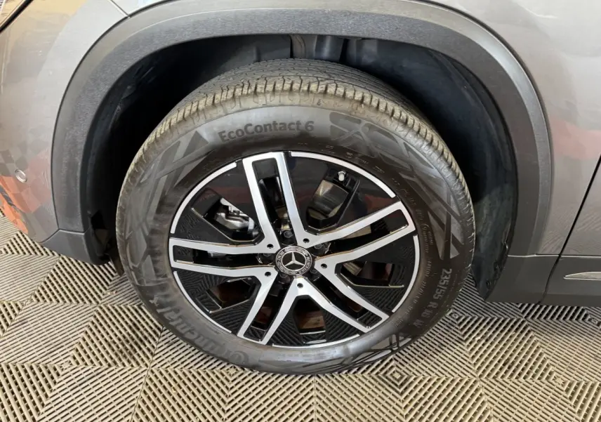 Gros plan sur la roue avant droite d’un Mercedes GLA 250 e gris foncé avec jante alliage noir et argent.