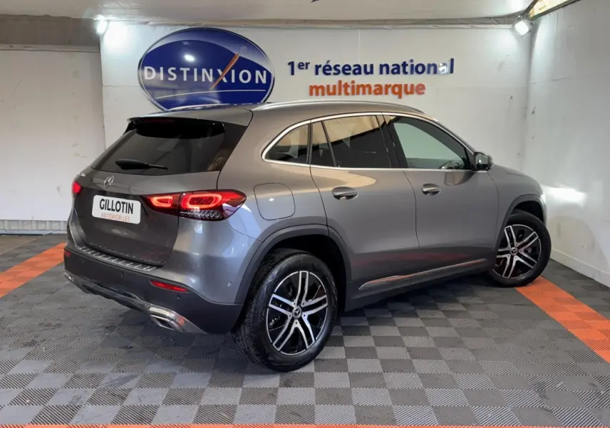 Vue 3/4 arrière droite d’un Mercedes GLA 250 e Business Line gris foncé avec feux LED et jantes alliage bicolores.