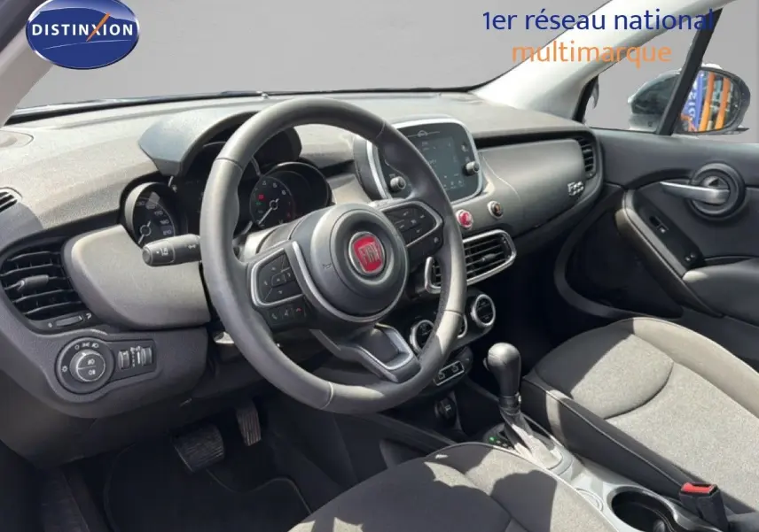Vue intérieure côté conducteur du tableau de bord et volant du Fiat 500X 2024, finition moderne et épurée.