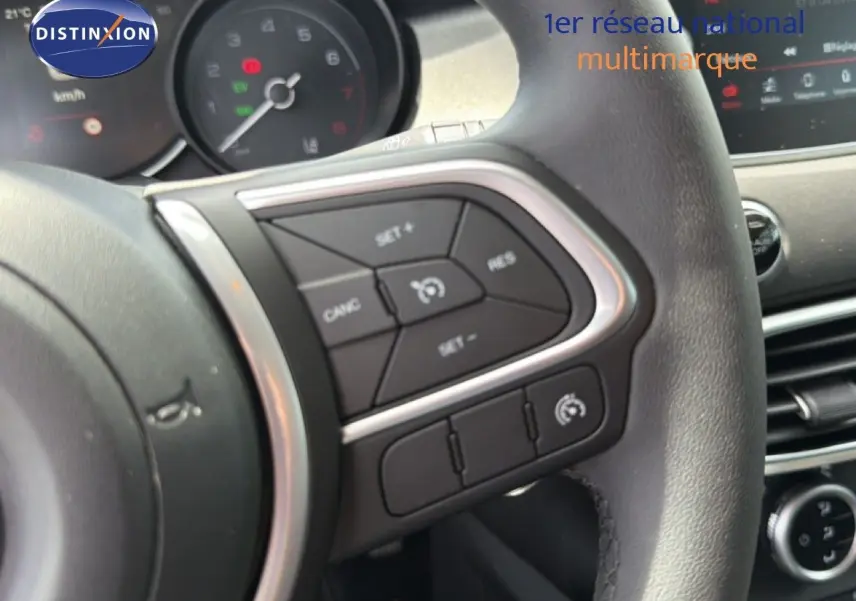 Détail du volant côté gauche avec commandes de régulateur de vitesse sur FIAT 500X 2024 hybride.