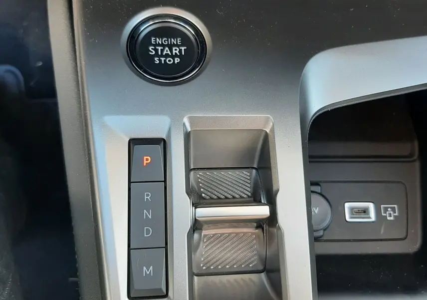 Gros plan sur la console centrale de la Peugeot 308 2024 blanche, montrant le bouton start/stop et la commande de boîte auto.
