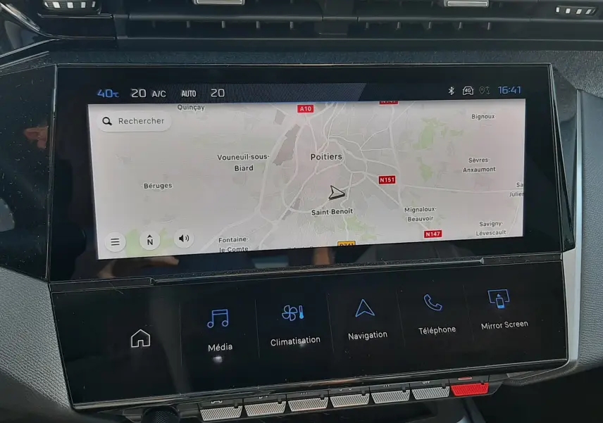 Vue rapprochée de l’écran tactile central du tableau de bord de la Peugeot 308 blanche, affichant la navigation GPS.
