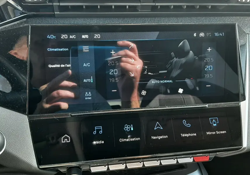 Vue rapprochée de l'écran tactile central de la Peugeot 308 2024, affichant les réglages de climatisation et multimédia.