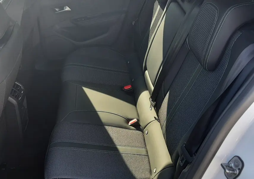 Vue intérieure côté droit des sièges arrière en tissu noir avec surpiqûres blanches d'une Peugeot 308 blanche 2024.