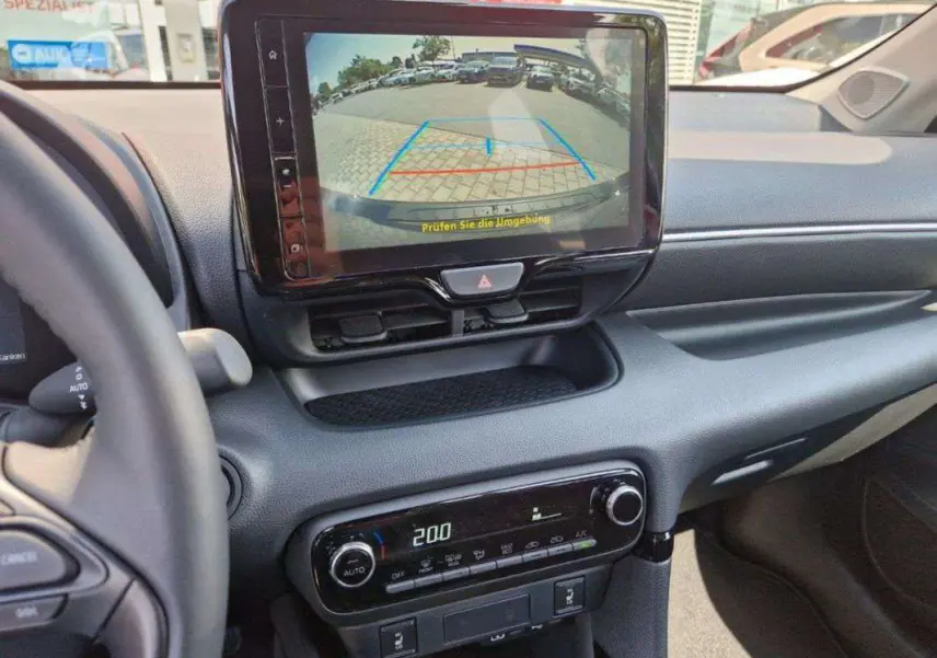 Vue intérieure du tableau de bord de la Toyota Yaris 2025 gris minéral, avec écran multimédia affichant la caméra de recul.