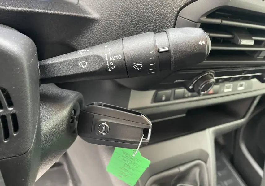 Gros plan sur la clé de contact et la commande d’essuie-glace dans l’habitacle du Opel Vivaro blanc 2024.