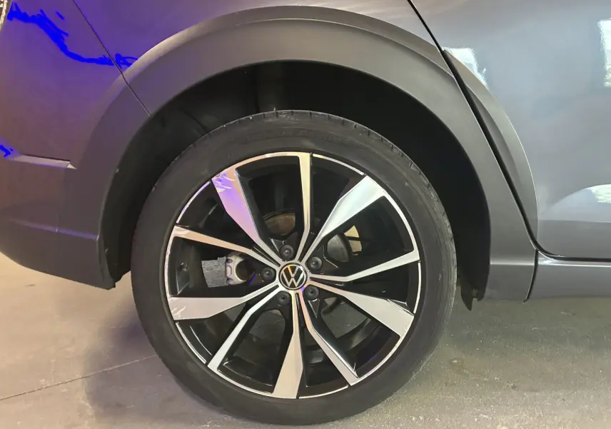 Gros plan sur la roue avant gauche du Volkswagen Taigo gris 2023, jante alliage R-LINE bicolore moderne.