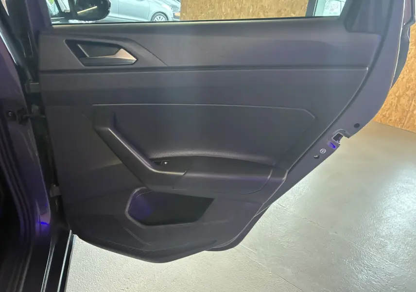 Vue rapprochée de la porte arrière gauche noire du Volkswagen Taigo 2023 finition R-LINE, intérieur tissu gris-noir.