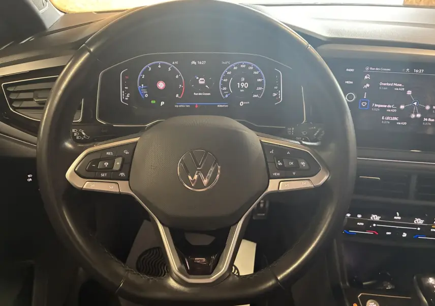 Vue rapprochée du volant noir du Volkswagen Taigo 1.5 TSI R-Line 2023 avec tableau de bord numérique et commandes intégrées.