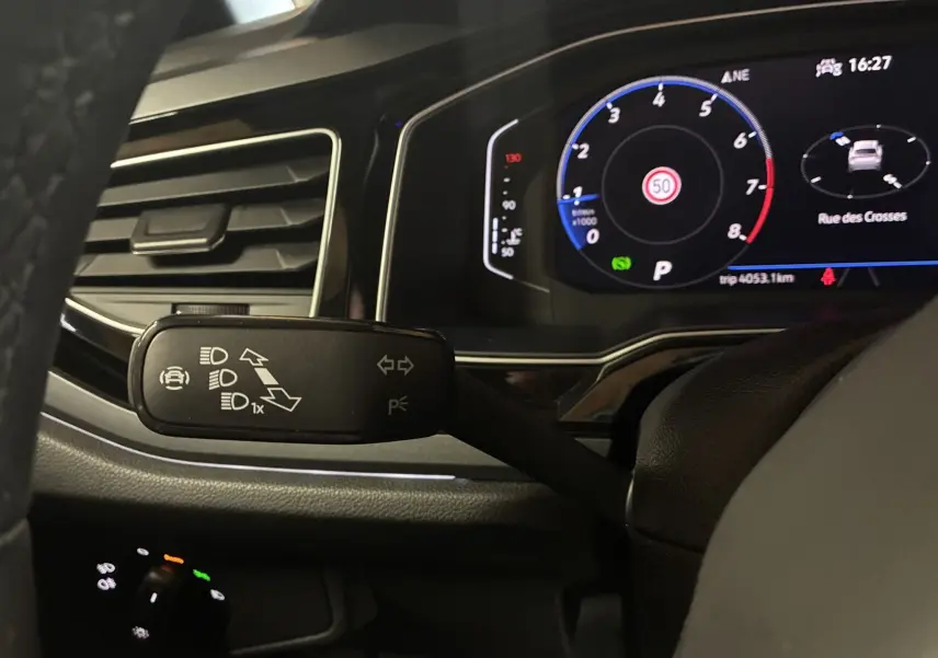 Gros plan sur la commande des clignotants et tableau de bord numérique du Volkswagen Taigo gris 2023, version R-LINE.