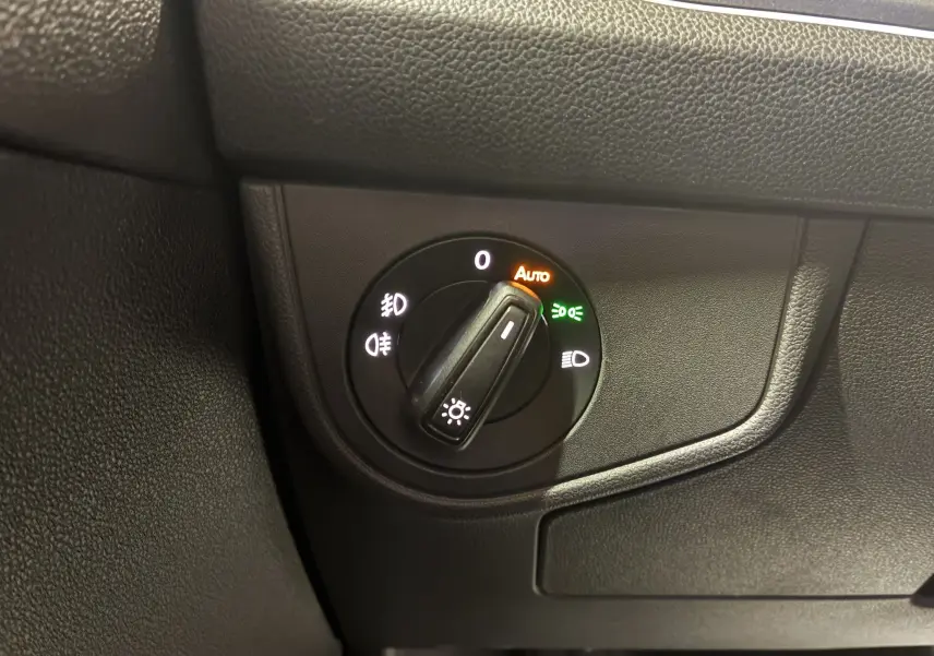 Gros plan sur le sélecteur de phares en position automatique dans l'habitacle gris-noir du Volkswagen Taigo 2023.