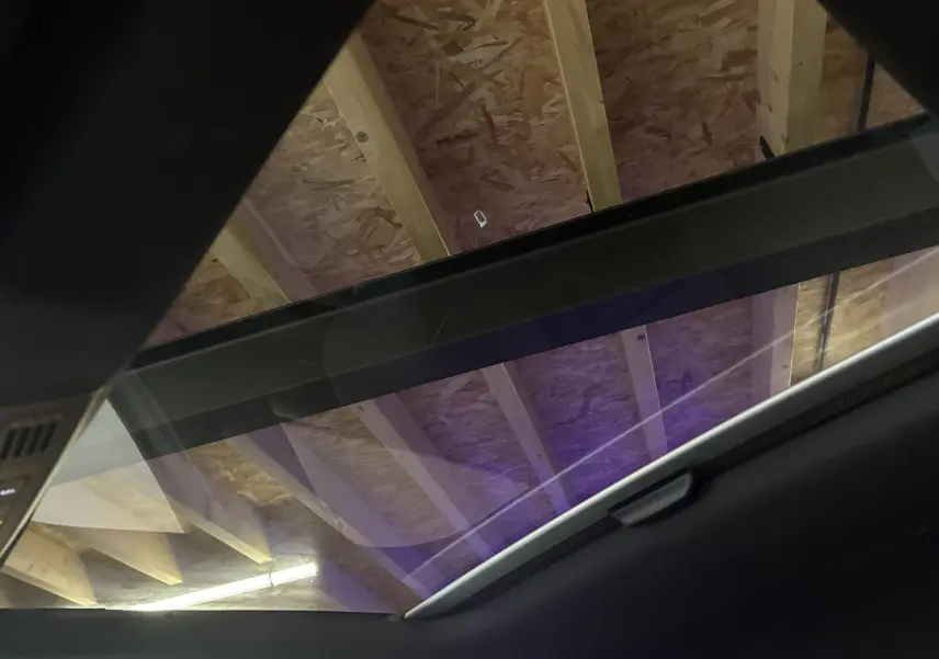 Toit panoramique en verre du Volkswagen Taigo gris 2023, vu de l'intérieur vers le plafond en bois.