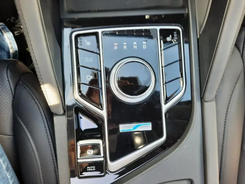 Gros plan sur la console centrale noire brillante du SERES 3 Luxury avec molette de boîte auto et commandes chauffantes.