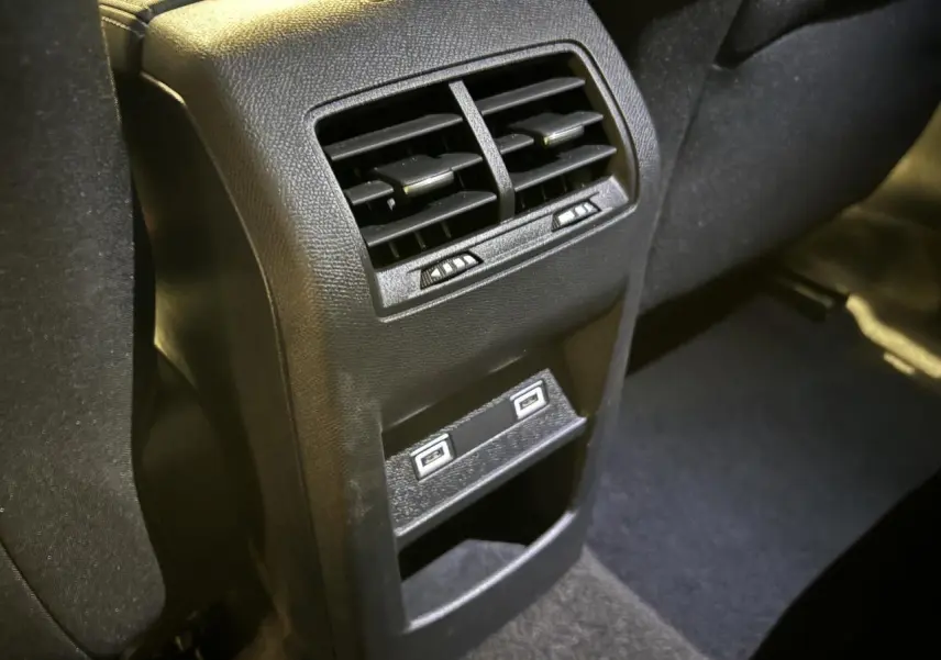 Vue rapprochée des aérateurs arrière et des deux prises USB C sur la console centrale d'une Peugeot 308 SW gris clair.