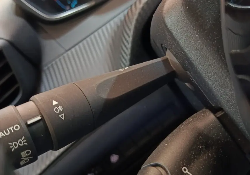 Détail intérieur du volant Peugeot 208 électrique blanc 2020, avec commandes de régulateur et affichage numérique.