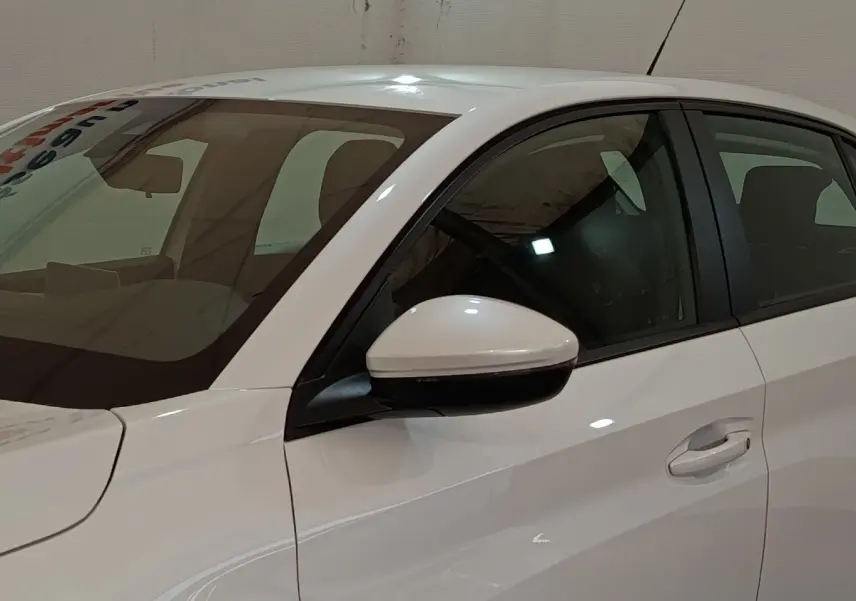 Vue latérale côté gauche d'une Peugeot 208 Electrique Active Business blanche, avec rétroviseur assorti.