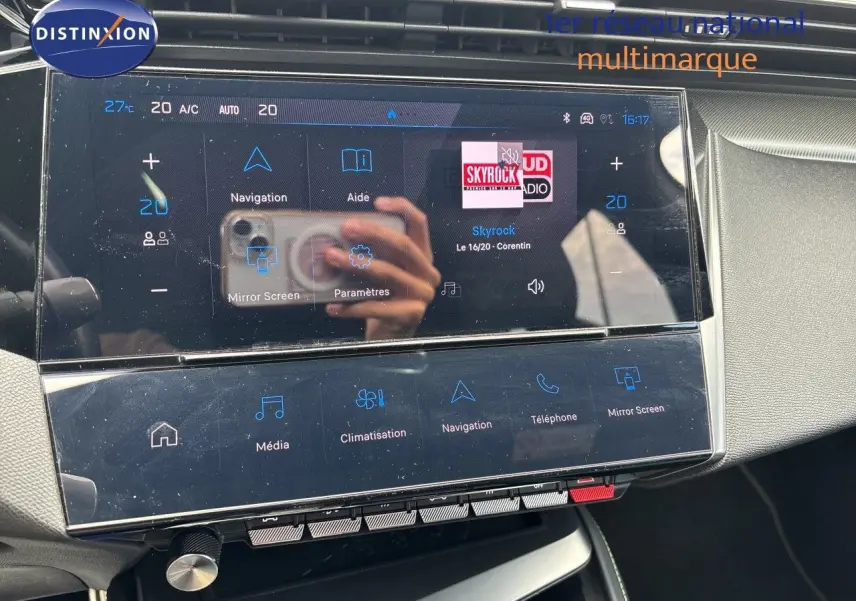 Écran tactile central de la Peugeot 308 SW hybride 2022, affichant la radio et les commandes de climatisation.