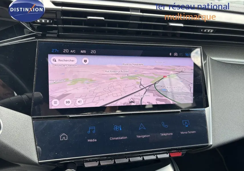 Vue rapprochée de l’écran tactile central du tableau de bord de la Peugeot 308 SW blanche nacrée, affichant la navigation.
