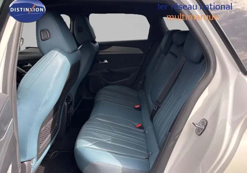 Vue intérieure côté droit des sièges arrière en cuir bleu d'une Peugeot 308 SW hybride blanc nacré 2022.
