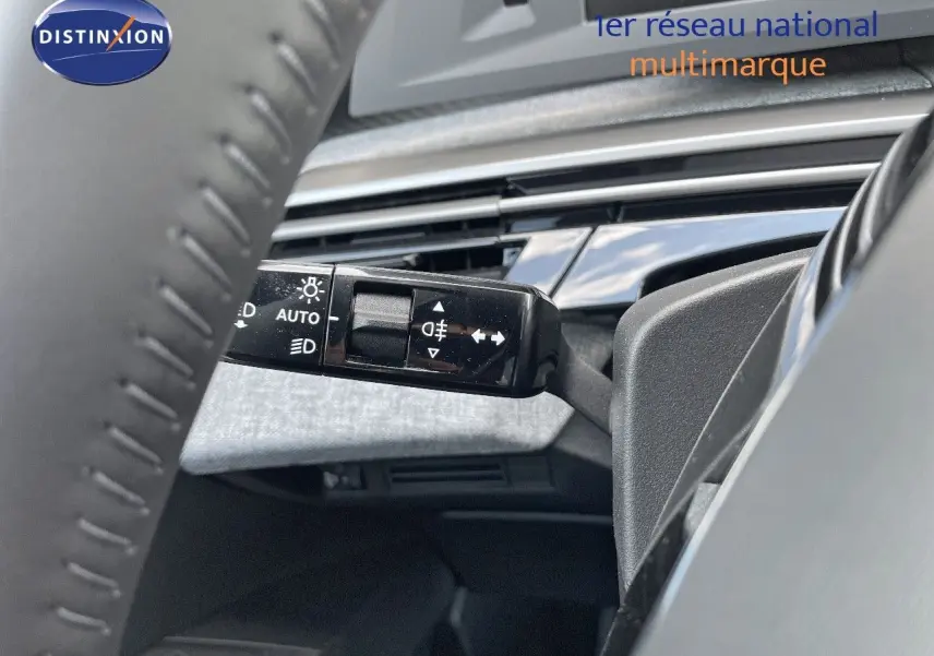 Gros plan sur la commande des feux et clignotants à gauche du volant dans l'habitacle d'un Peugeot 3008 bleu Ingaro Metal 2025