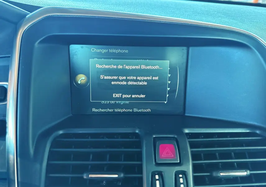 Vue rapprochée de l'écran central et des aérateurs d'un Volvo XC60 gris 2016, affichant la recherche Bluetooth.