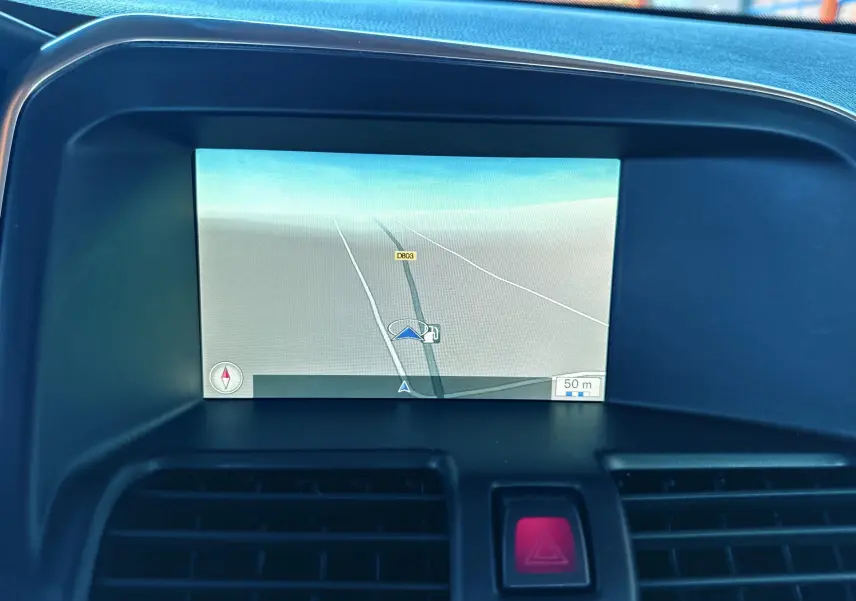 Écran de navigation intégré au tableau de bord du Volvo XC60 gris 2016, affichant une carte routière simple.