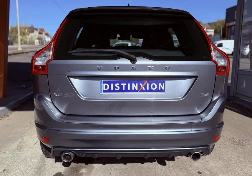 Vue arrière d'un Volvo XC60 D4 gris 2016 avec double sortie d'échappement et logo Distinxion sur la plaque.