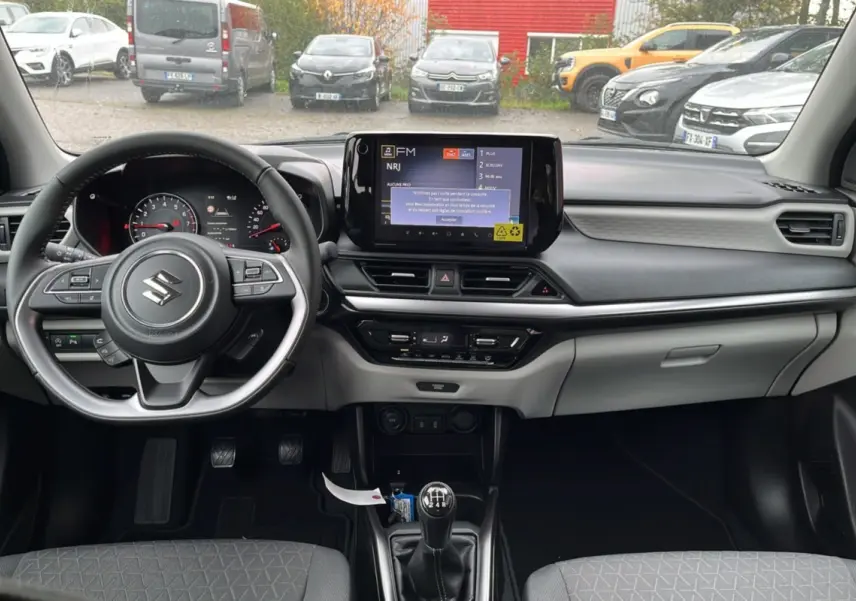 Intérieur de la Suzuki Swift 1.2 Dualjet Hybrid Allgrip Pack 2025, vue frontale du tableau de bord et volant cuir multifonctions.