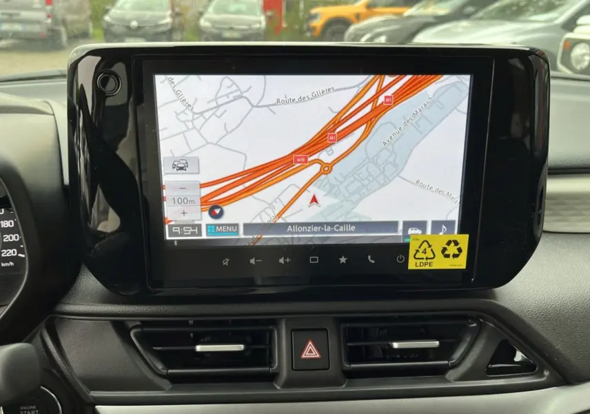 Écran central tactile du Suzuki Swift 2025 affichant la navigation GPS avec carte routière en intérieur noir.