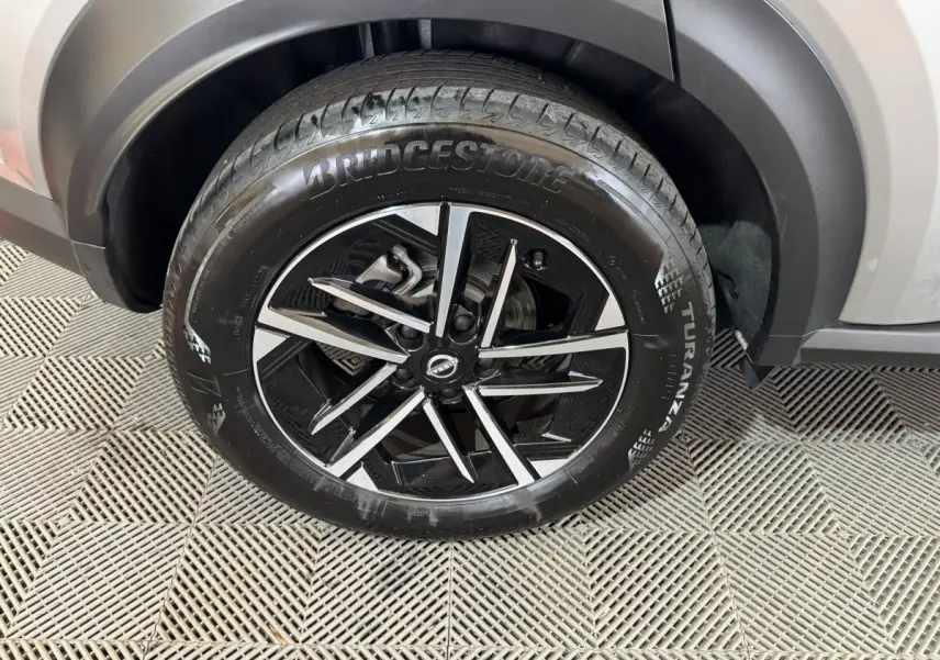 Gros plan sur la roue avant droite gris clair du Nissan Juke 2025 avec jante noire et argentée au design moderne.