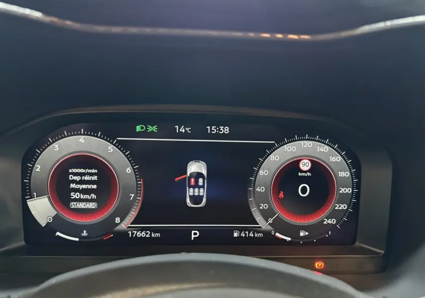 Vue rapprochée du combiné d'instruments numérique du Nissan Juke gris clair, affichant vitesse, régime et alertes.