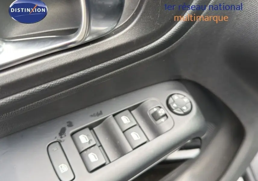 Gros plan sur les commandes des vitres électriques côté gauche d’un Citroën C5 Aircross Hybrid 145 gris platinium.